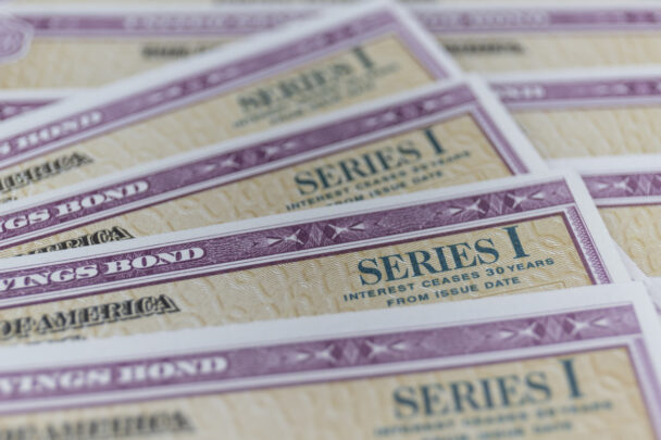overlapping savings bonds cropped to emphasize writing on the bond that says "Series One"